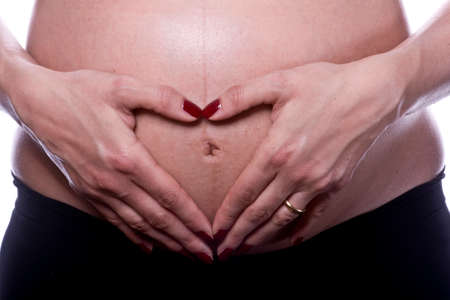 Woman hands on pregnant belly shooting in studioの写真素材