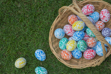 Many colored Easter eggs in a Wicker basket, On the grass, Birdseye shotの写真素材