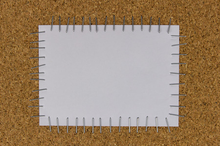 white paper attached on the cork brown board by staplerの写真素材