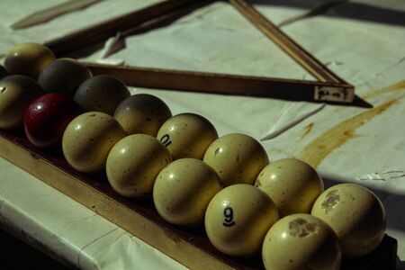 antique billiard balls in the old room and on the old table covered with white paper. inscription:...