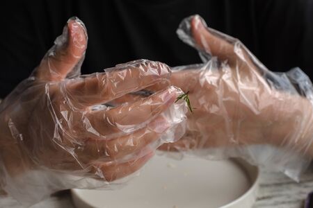 personal hygiene during a pandemic. the girl is eating a croissant in transparent disposable gloves. personal hygiene during illness and viruses. disposable personal hygiene itemsの写真素材