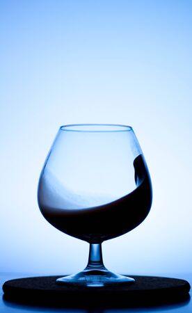 a splash of liquid in a glass wine glass. water pouring inside a glass wine glass. a curl of water in a wine glass. drink in a glass wine glass .splash in the glassの写真素材