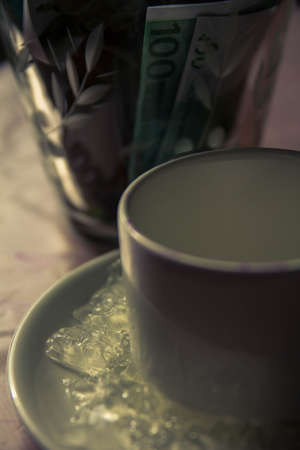 yellow dry flowers in a vase where instead of water of money. flowers grow out of money. vase floor money Euro dollarsの写真素材