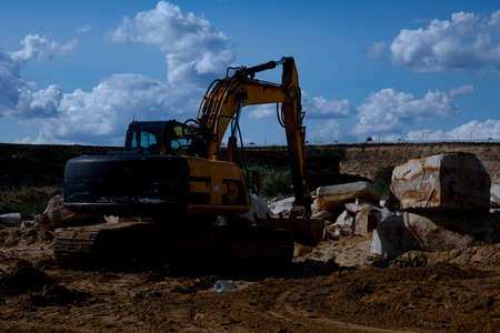 Dump truck transports sand in open pit mine. Excavator on the development of sand in a quarry....