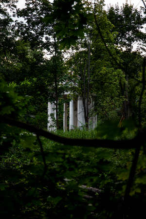an abandoned old gazebo for tea drinking that has been preserved in Russia since tsarist times. beautiful old building on an island in the foliageの写真素材