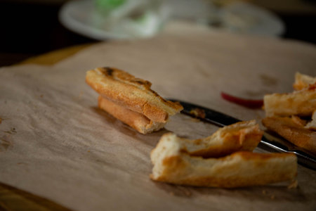 slices of bitten pizza lying on a tray next to a knife and fork pizza crusts