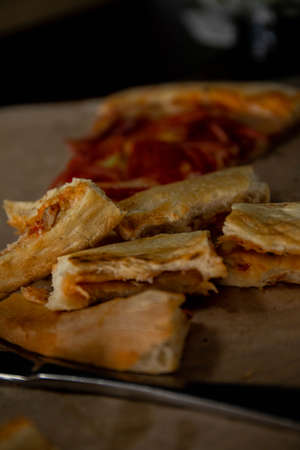 slices of bitten pizza lying on a tray next to a knife and fork pizza crustsの写真素材