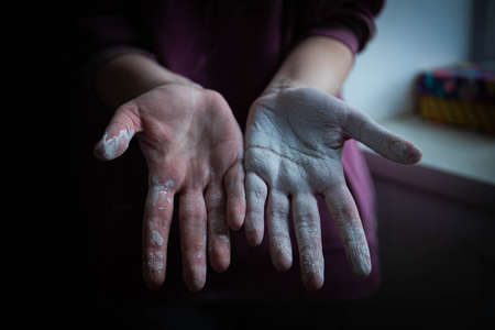beautiful women's hands smeared in white paint after working with their hands. home renovation. painting works. hands covered in paint. whitewashing the textureの写真素材