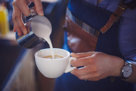 girl shows how to make a latteの写真素材