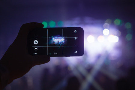 The man writes a rock concert on a smartphoneの写真素材