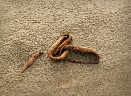 Background with a rusty old chain on sand   の写真素材