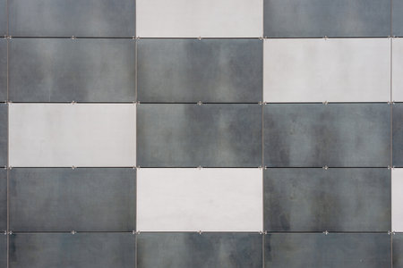 abstract background of gray and white square tiles on the facade of a building