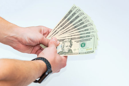 Hand holding dollar banknotes on a white background, business concept.