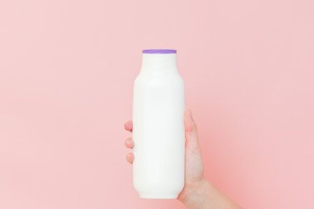 Shampoo, hair conditioner bottle or a body lotion in female hands. Cosmetics bottleの写真素材