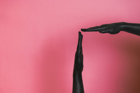 Gesticulation of the black painted elegant woman's hands on her skin. High Fashion art conceptの写真素材