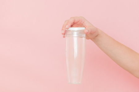 Female hand holds a blank cosmetic container. Cosmetic beauty packagingの写真素材
