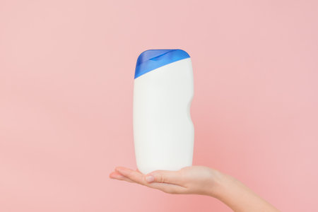 Woman's hands holding shampoo, hair conditioner bottle or a body lotion. Cosmetics bottleの写真素材