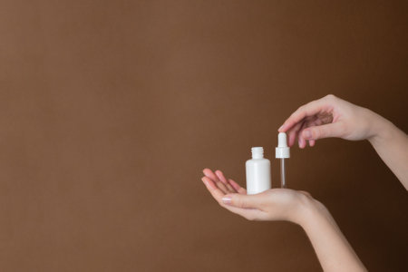 Serum glass unbranded tube or essential oil with pipette on a brown background. Persenting luxury skincare productsの写真素材