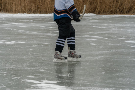 Close-up of hockey player and stick on frozen lakeの写真素材