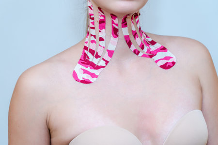Kinesio tapes on the neck of beautiful young woman on white backgroundの写真素材