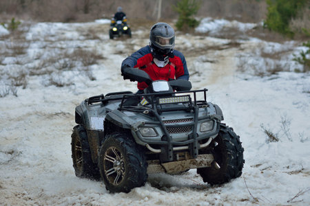 ATV and UTV driving in mud and snow at winter