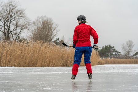 Ice hockey player with stick in action on a frozen lake
