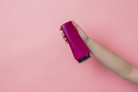 Cosmetic unbranded bottle for shampoo, mask, lotion with a pink background. Concept of beauty. Product cosmetic advertisingの写真素材