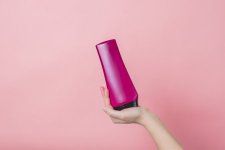 Cosmetic unbranded bottle for shampoo, mask, lotion in a hand. Concept of beauty. Product cosmetic advertisingの写真素材