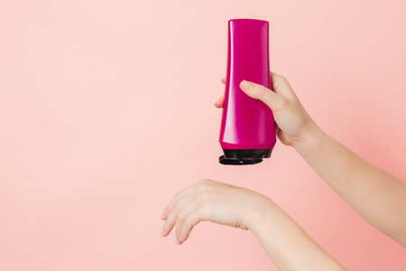 Cosmetic unbranded bottle for shampoo, mask, lotion in the hands. Concept of beauty. Product cosmetic advertisingの写真素材