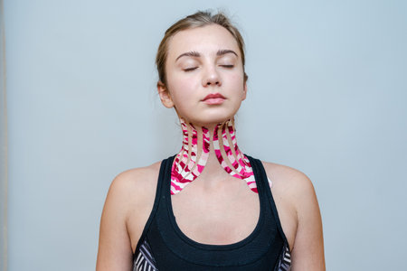 Young woman with tape for a facelift with medical tape. Esthetic taping. Salon procedures