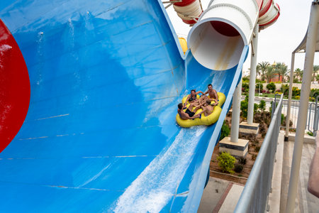 Friends having fun and rolling on big water slideの写真素材