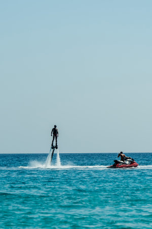 Man on flyboard above the azure sea. Water sport adventure