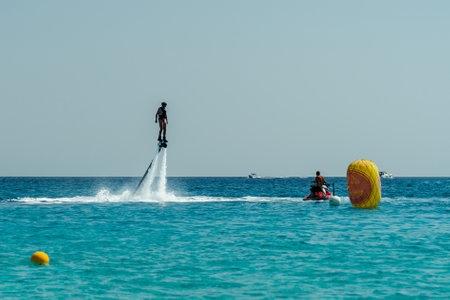 Man on flyboard above the azure sea. Water sport adventure
