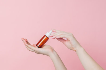 Serum glass brown bottle (essential oil) with pipette in the hands. Product cosmetic advertisingの写真素材