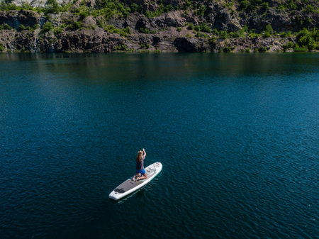 Aerial view on woman on sup board in the lake