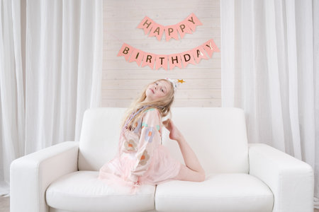 Amazing small blond girl celebrating birthday. Decoration and photo zone for the girls birthday...