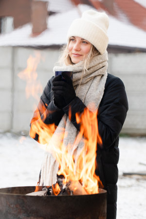Happy young woman with hot cup of cocoa or tea in a winter.の写真素材