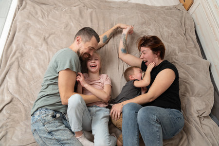 Smiling parents having fun with kids at a home. Happy family momentsの写真素材