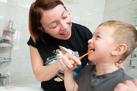 Parents helping to son brush teeth. Happy familyの写真素材