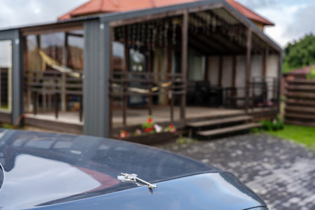 House keys on car in front of a modern new house. Moving relocation, mortgage, property, real estate concept. Buying or rentingの写真素材