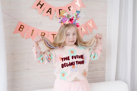 Happy blond girl celebrating birthday. Decoration and photo zone for the girls birthday party