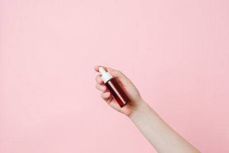 Serum glass brown bottle (essential oil) with pipette in a hand. Product cosmetic advertisingの写真素材