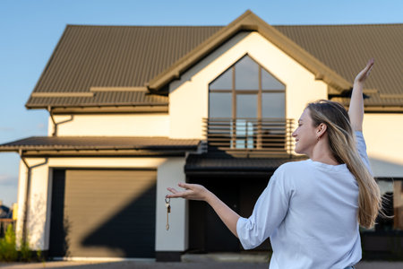 Happy woman with keys with a new house background. Property lease real estate for relocation. Leasing insurance and purchase. Buying or rentingの写真素材