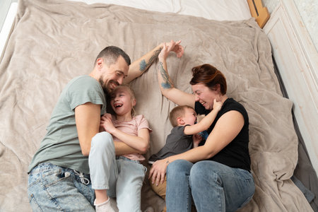 Smiling parents having fun with kids at a home. Happy family momentsの写真素材