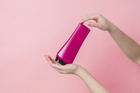 Cosmetic unbranded bottle for shampoo, mask, lotion with a pink background. Concept of beauty....