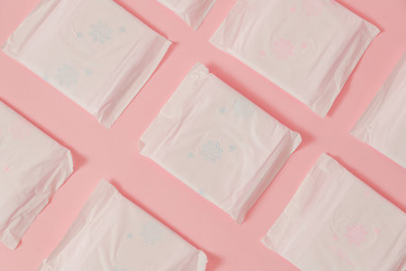 Flat layout of sanitary napkins on a pink background. Menstruation cycle, feminine hygiene and...