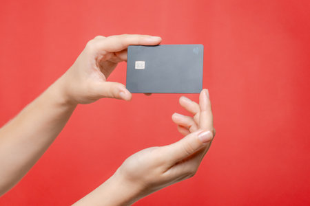 Close up blank credit card with online service for mockup in hand on a pink background. Modern way...