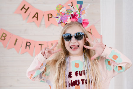 Amazing small blond girl celebrating birthday. Decoration and photo zone for the girls birthday...