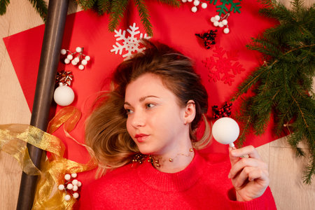 Portrait of smiling young woman lying on a New Year's wrapping paper.の写真素材