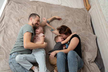 Smiling parents having fun with kids at a home. Happy family momentsの写真素材